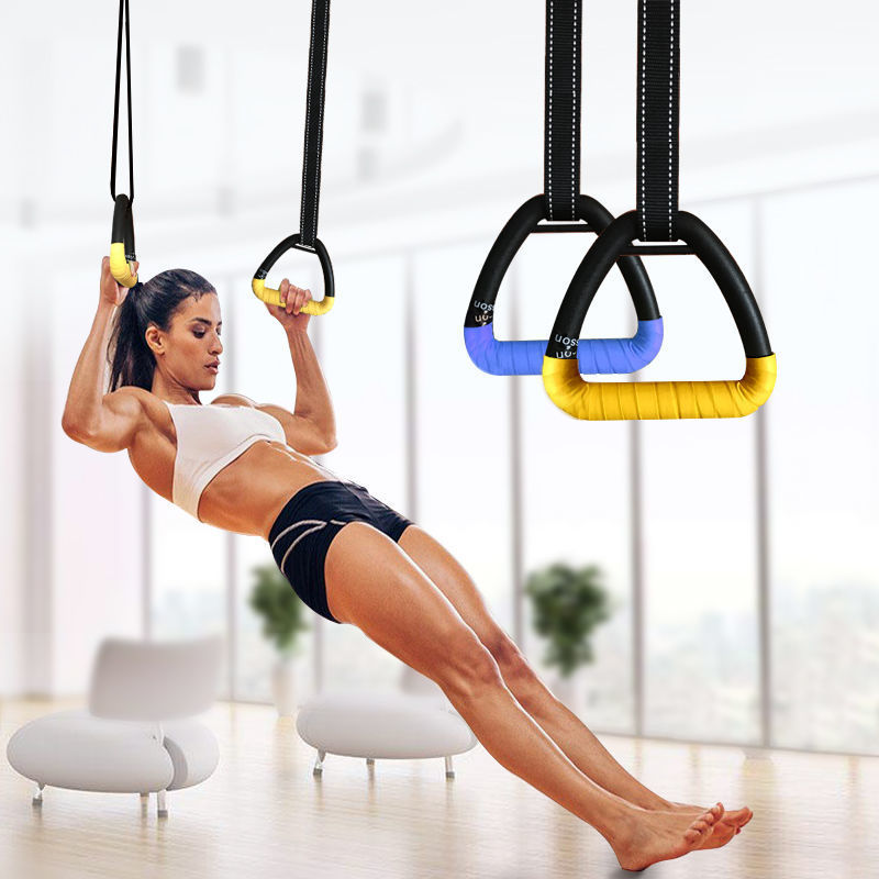 Woman performing bodyweight rows using adjustable gymnastic rings with yellow strap wrap